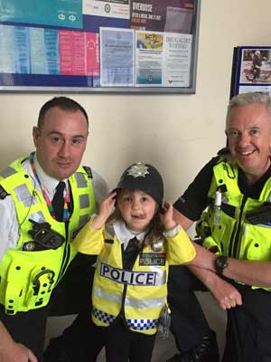 young child wearing police uniform